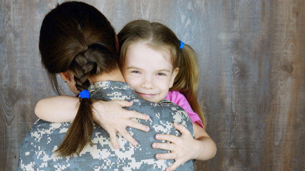 Smiling toddler hugging a woman